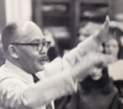 A picture of I. Sherman Greene conducting musicians